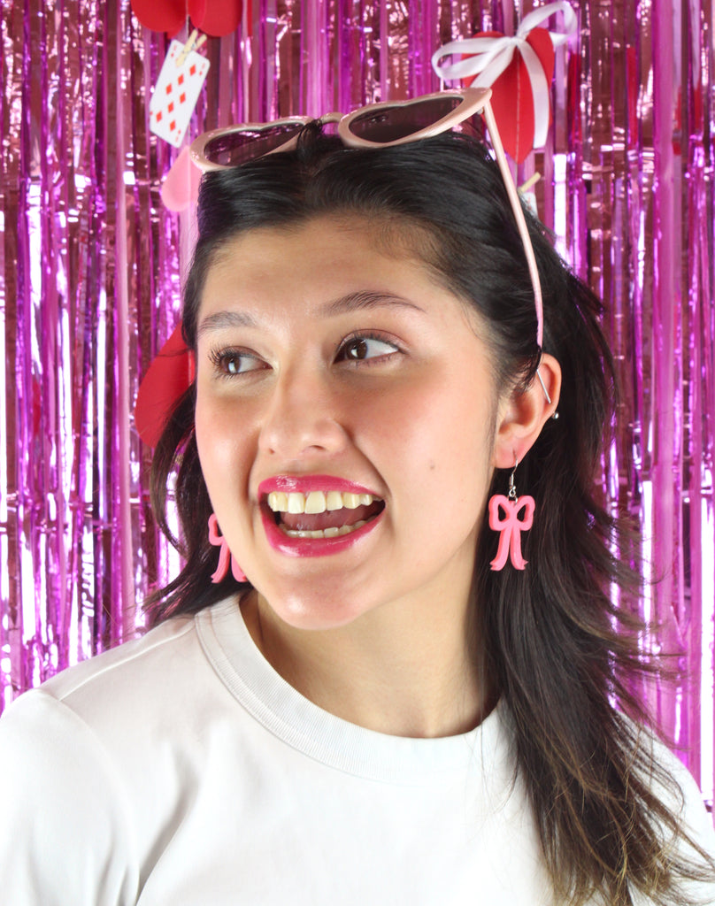 Model wearing Rose pink bow shaped charms on stainless steel earwires