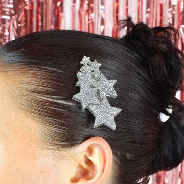 Model wearing a hair clip made up of a cluster of silver glittery stars