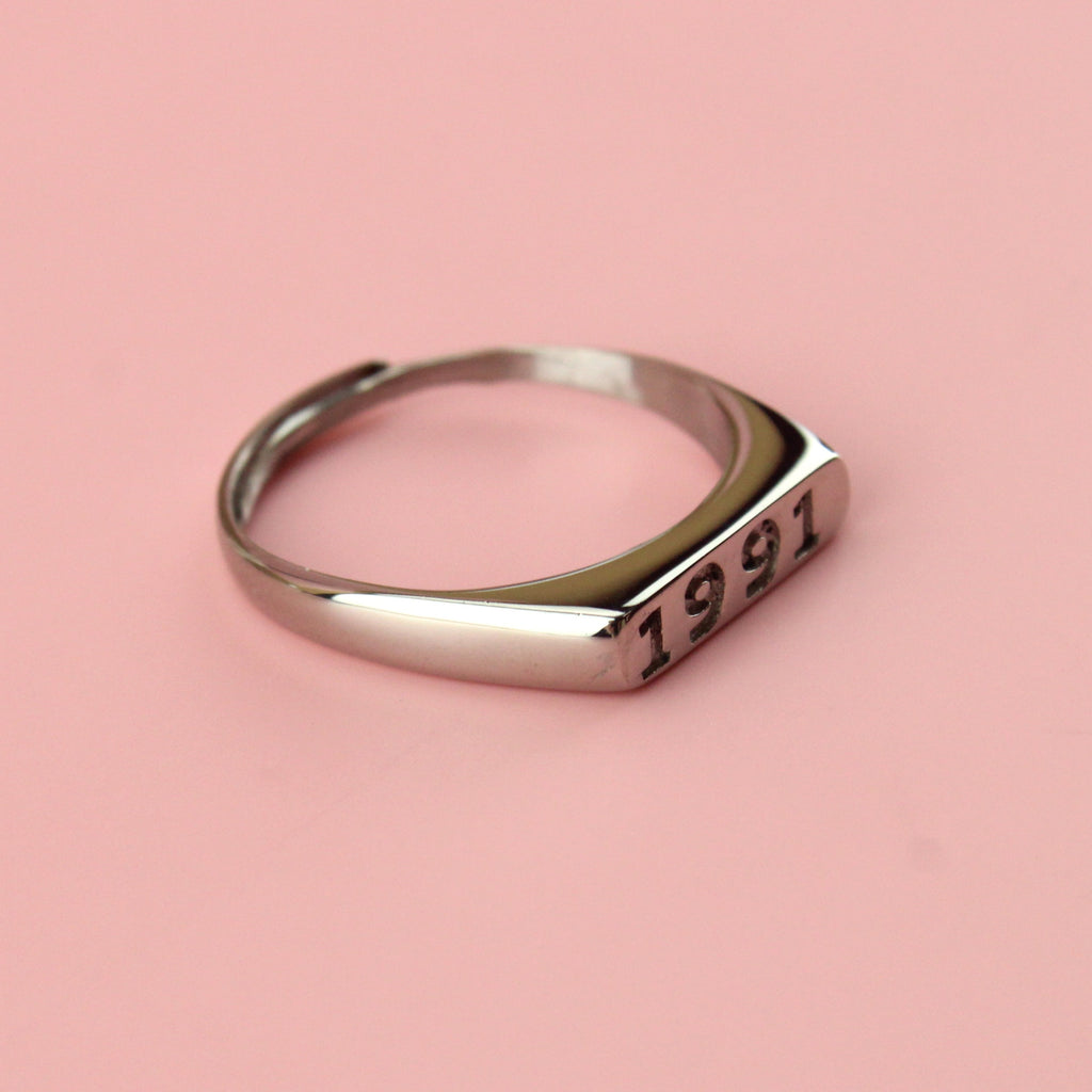 Stainless steel ring with 1991 engraved on the front