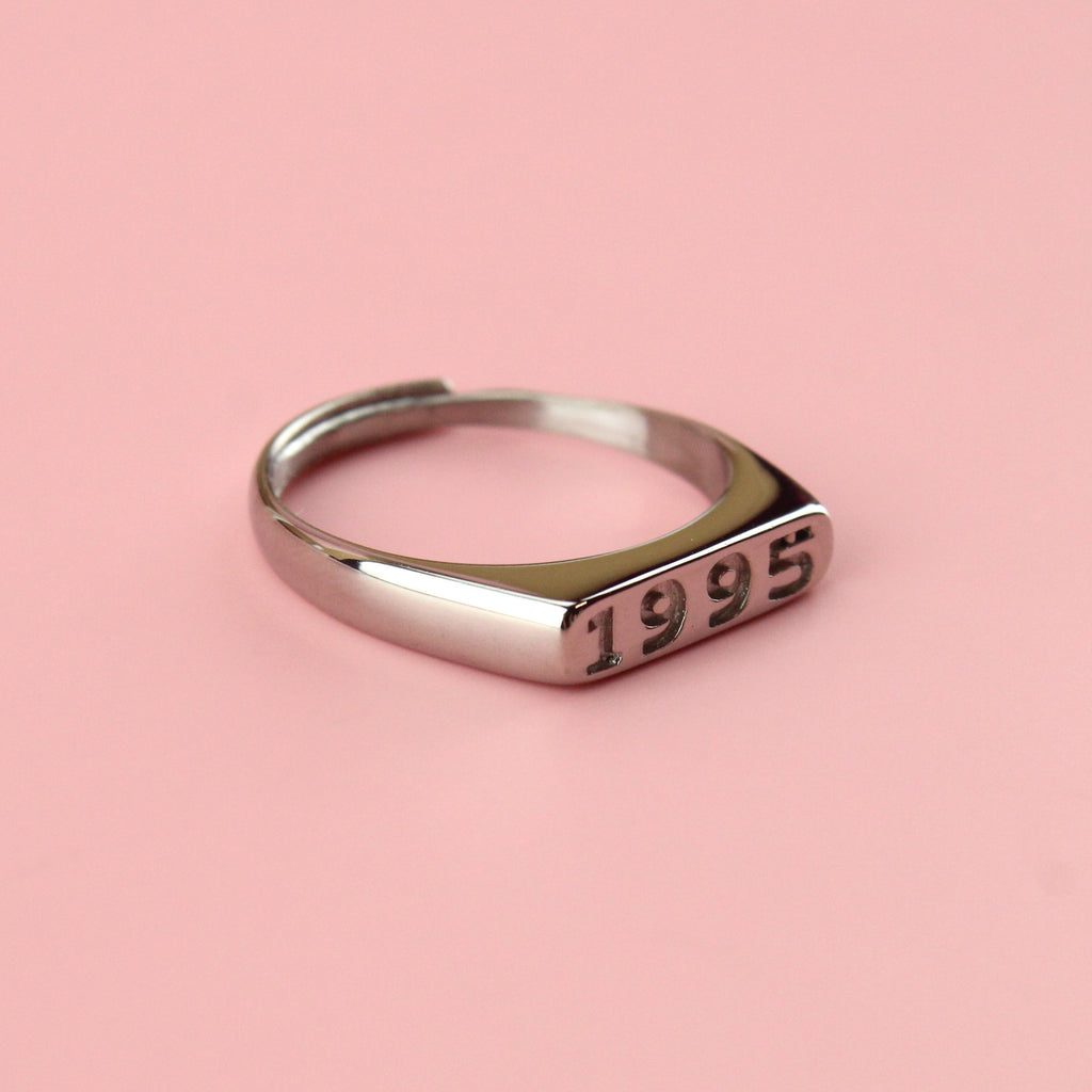 Stainless steel ring with 1995 engraved on the front