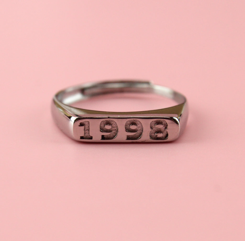 Stainless steel ring with 1998 engraved on the front