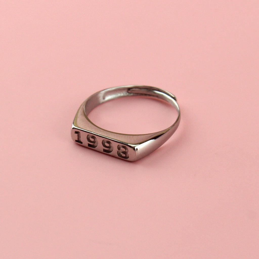 Stainless steel ring with 1998 engraved on the front