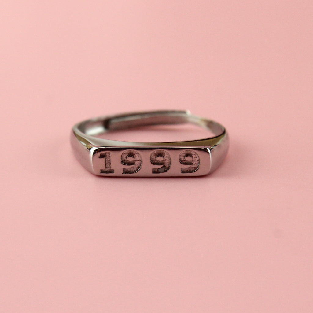 Stainless steel ring with 1999 engraved on the front