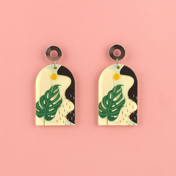 Stainless steel studs with acrylic charms featuring a monstera print and abstract view