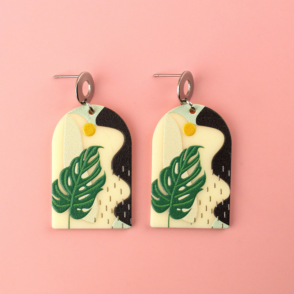 Stainless steel studs with acrylic charms featuring a monstera print and abstract view