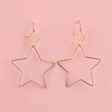 A small gold star connected to a larger gold star hung from gold plated stainless steel earwires