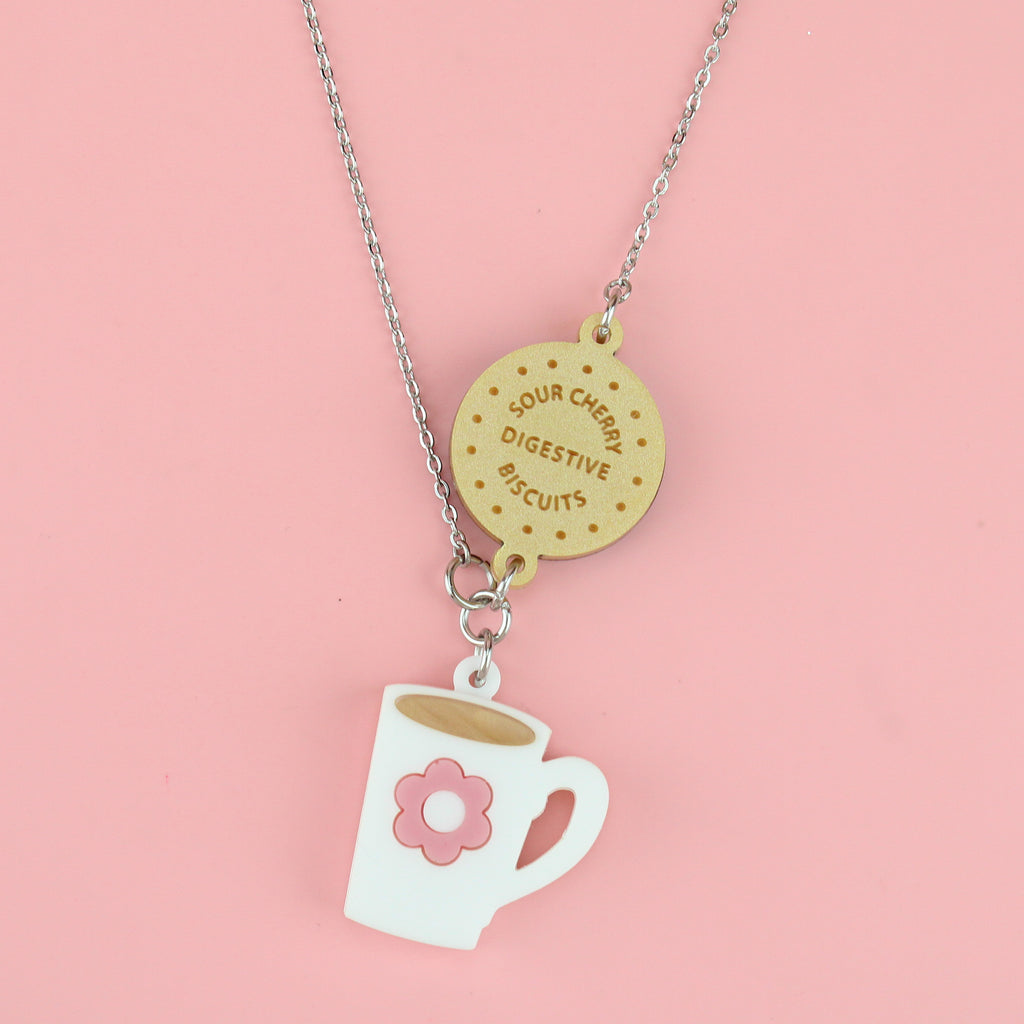 Stainless steel chain with a chocolate digestive pendant reading 'Sour Cherry Digestive Biscuits' and a cup of tea pendant featuring a pink flower design