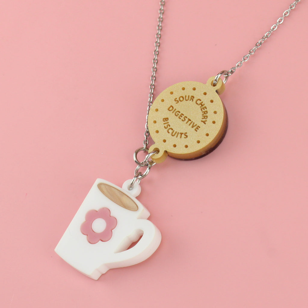 Stainless steel chain with a chocolate digestive pendant reading 'Sour Cherry Digestive Biscuits' and a cup of tea pendant featuring a pink flower design
