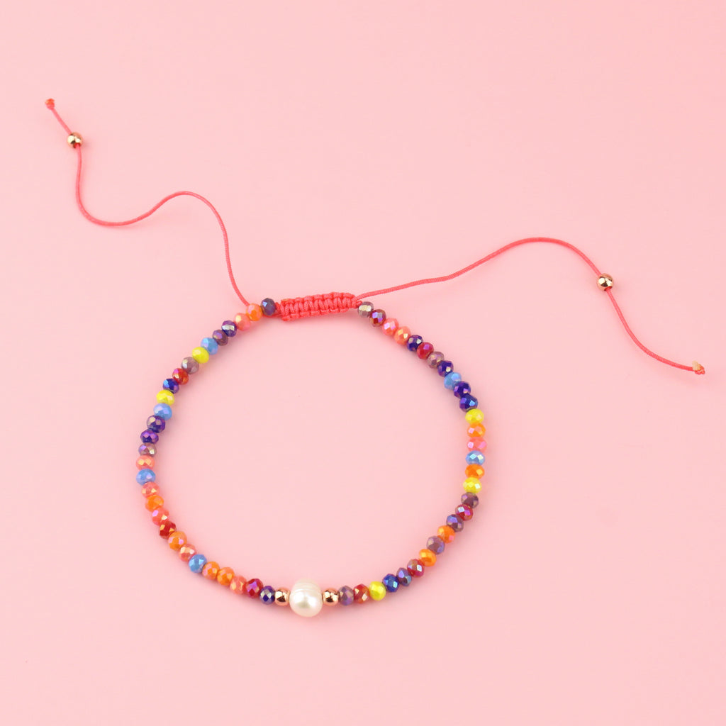Multicoloured glass beads and a faux pearl on an adjustable nylon thread bracelet