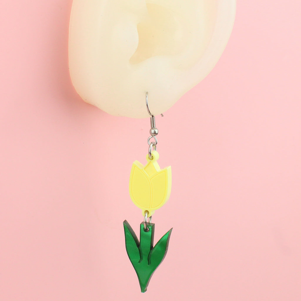 Ear wearing Yellow acrylic tulip charms with green stems on stainless steel earwires