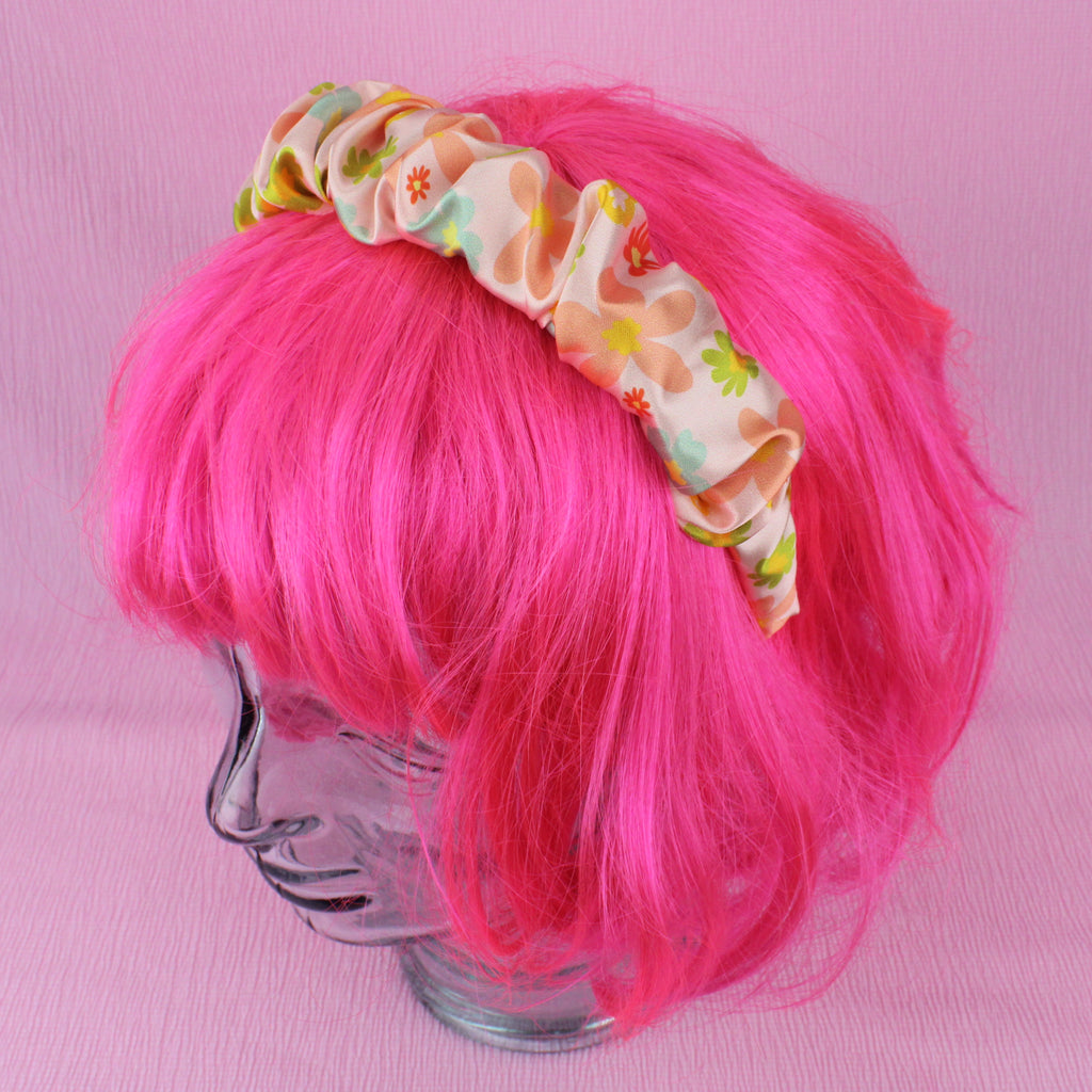 Welcome To The Sixties Headband shown on a wig for scale