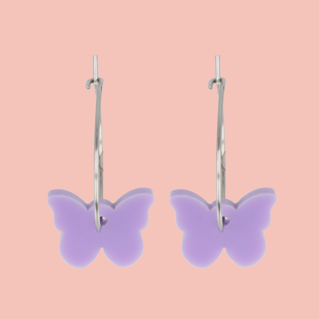 Butterfly-shaped earrings on a pink background