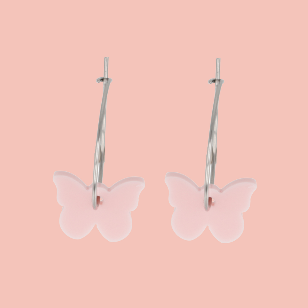 Butterfly-shaped earrings on a pink background