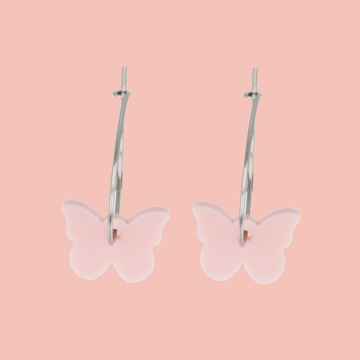 Butterfly-shaped earrings on a pink background