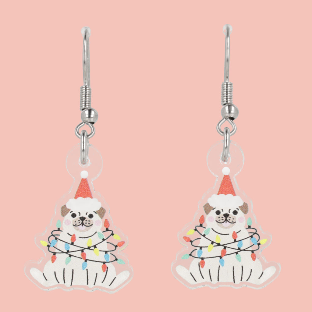 Pair of earrings with pug dog design wearing a Santa hat and lights on a pink background