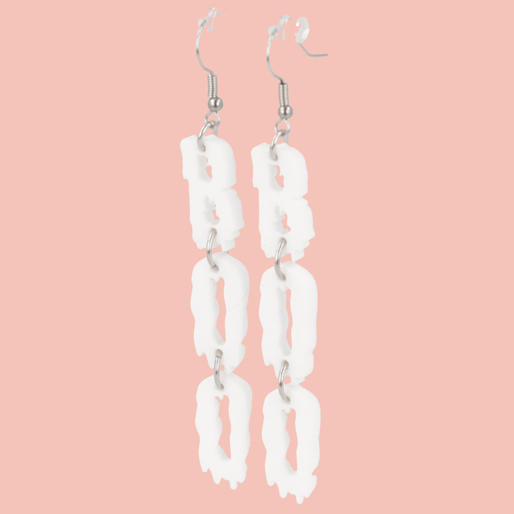 THE LETTERS B, O, O SPELLED OUT VERTICALLY WITH A WHITE DRIPPY EFFECT ON STAINLESS STEEL EARWIRES