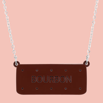 Necklace with a bourbon biscuit pendant on a pink background