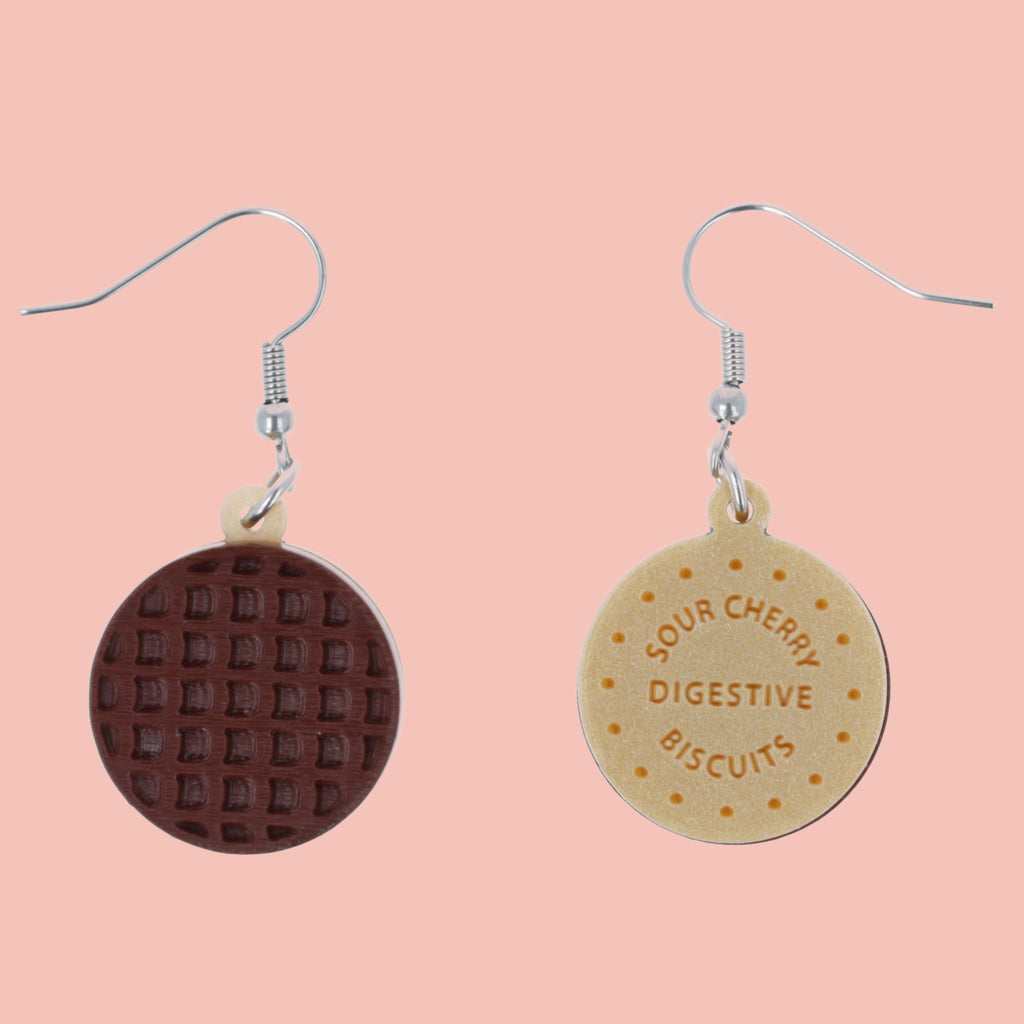 Chocolate digestive earrings on a pink background