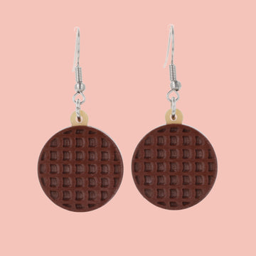 Chocolate digestive earrings on a pink background