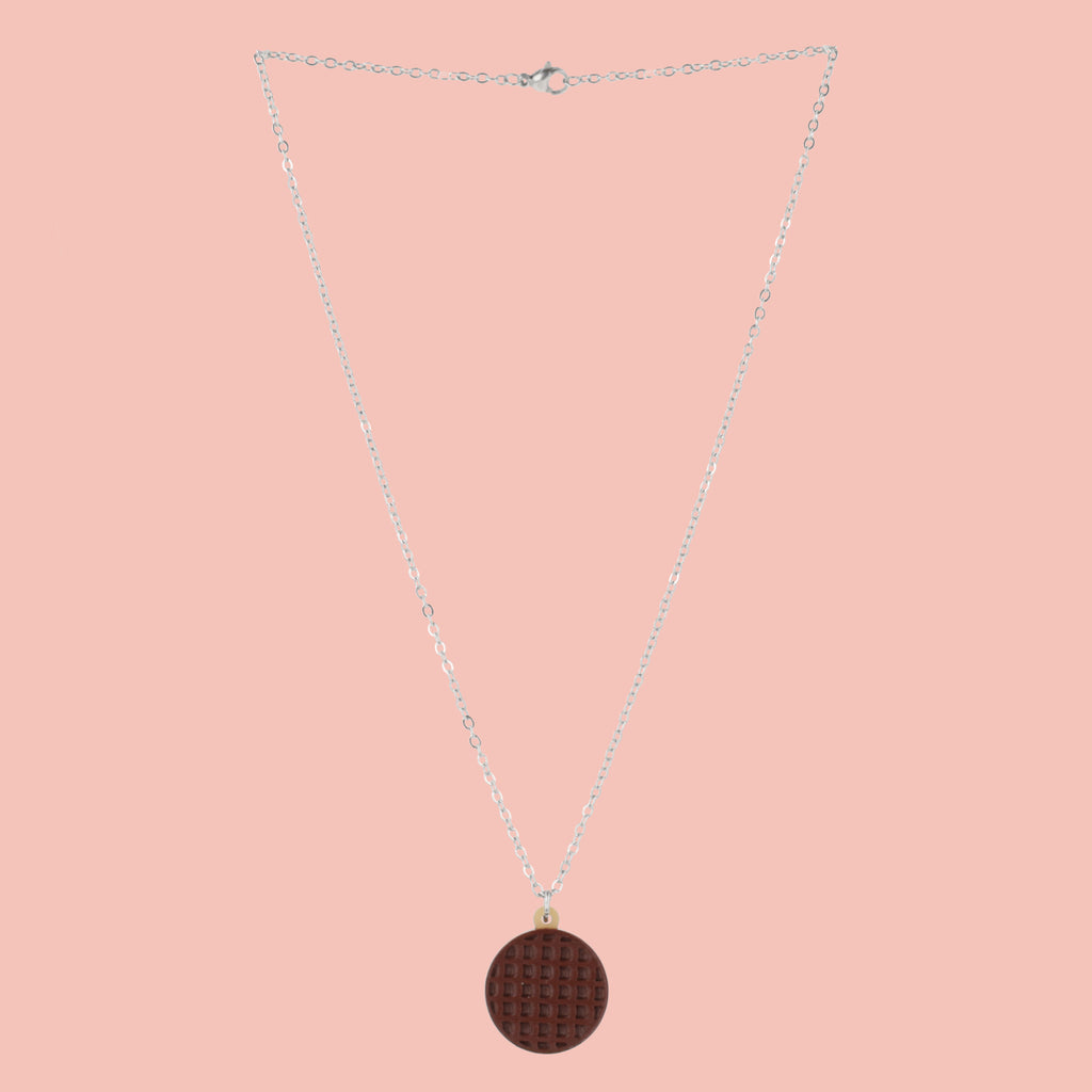 Necklace with a chocolate digestive pendant on a pink background