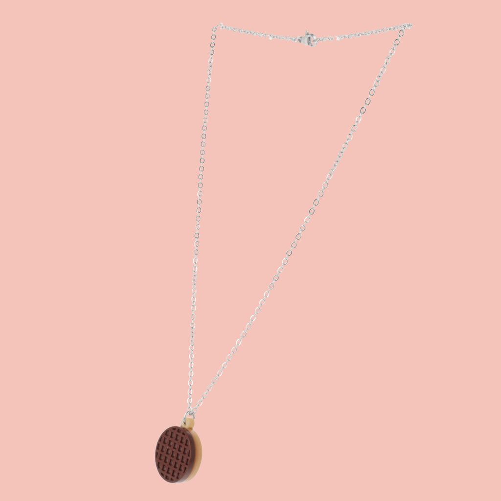Necklace with a chocolate digestive pendant  on a pink background