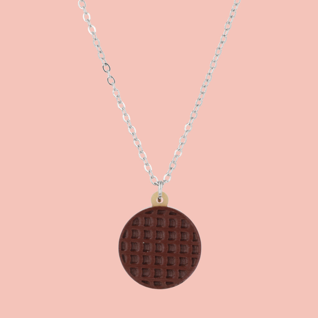 Necklace with a chocolate digestive pendant on a pink background