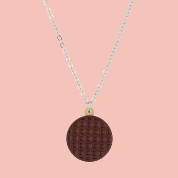 Necklace with a chocolate digestive pendant on a pink background