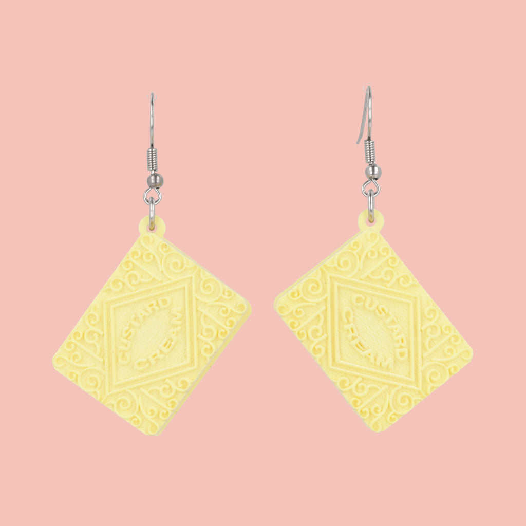 Custard cream earrings on a pink background