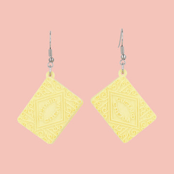 Custard cream earrings on a pink background
