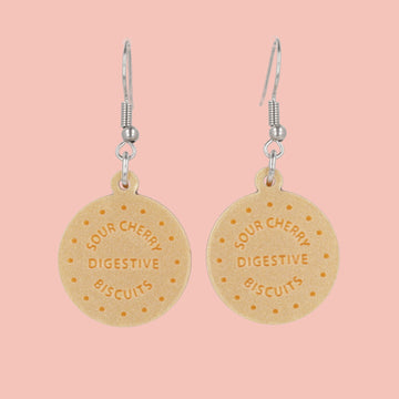 Digestive biscuit earrings on a pink background