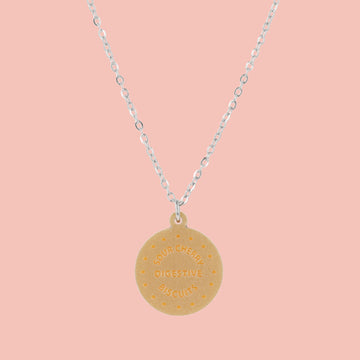 Necklace with a digestive biscuit pendant on a pink background