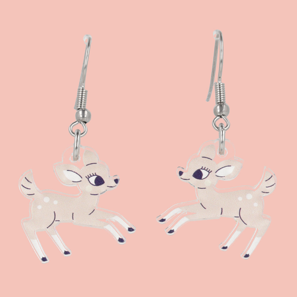 Deer-shaped earrings on a pink background
