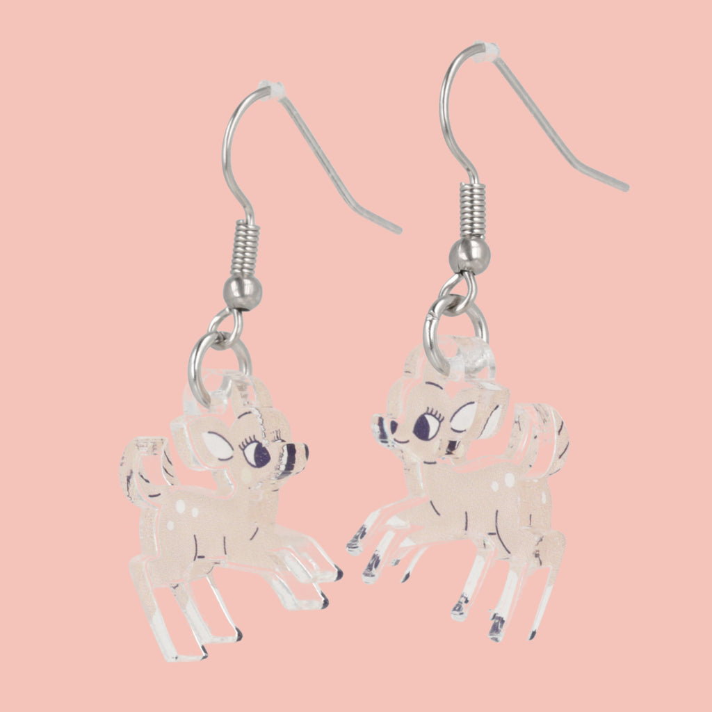 Deer-shaped earrings on a pink background