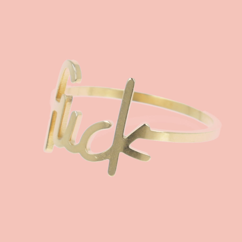 Gold plated titanium ring with the word f*ck printed on the front