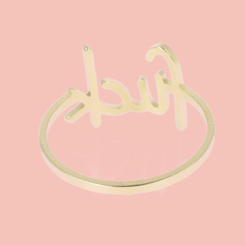 Gold plated titanium ring with the word f*ck printed on the front