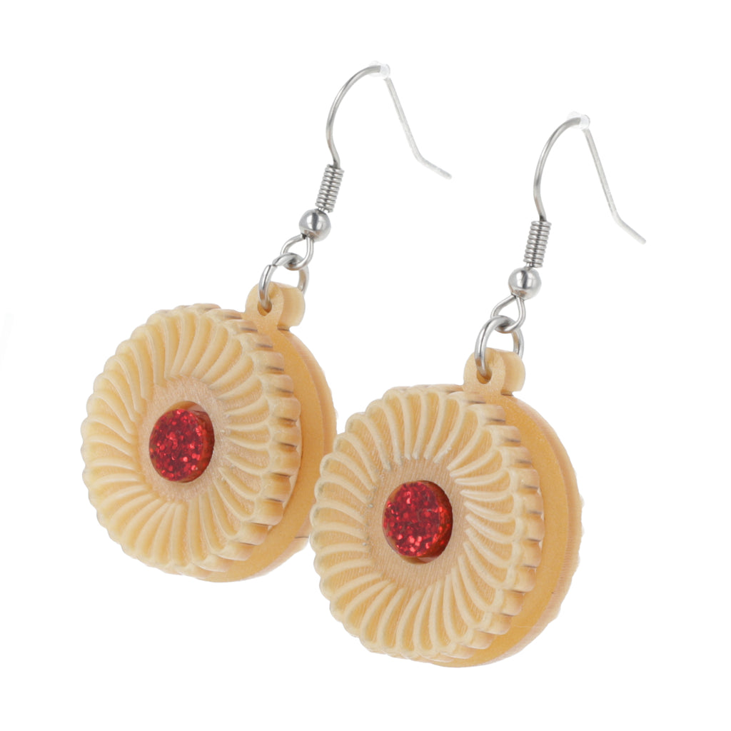 Pair of earrings with jam and cream biscuit charms on a white background