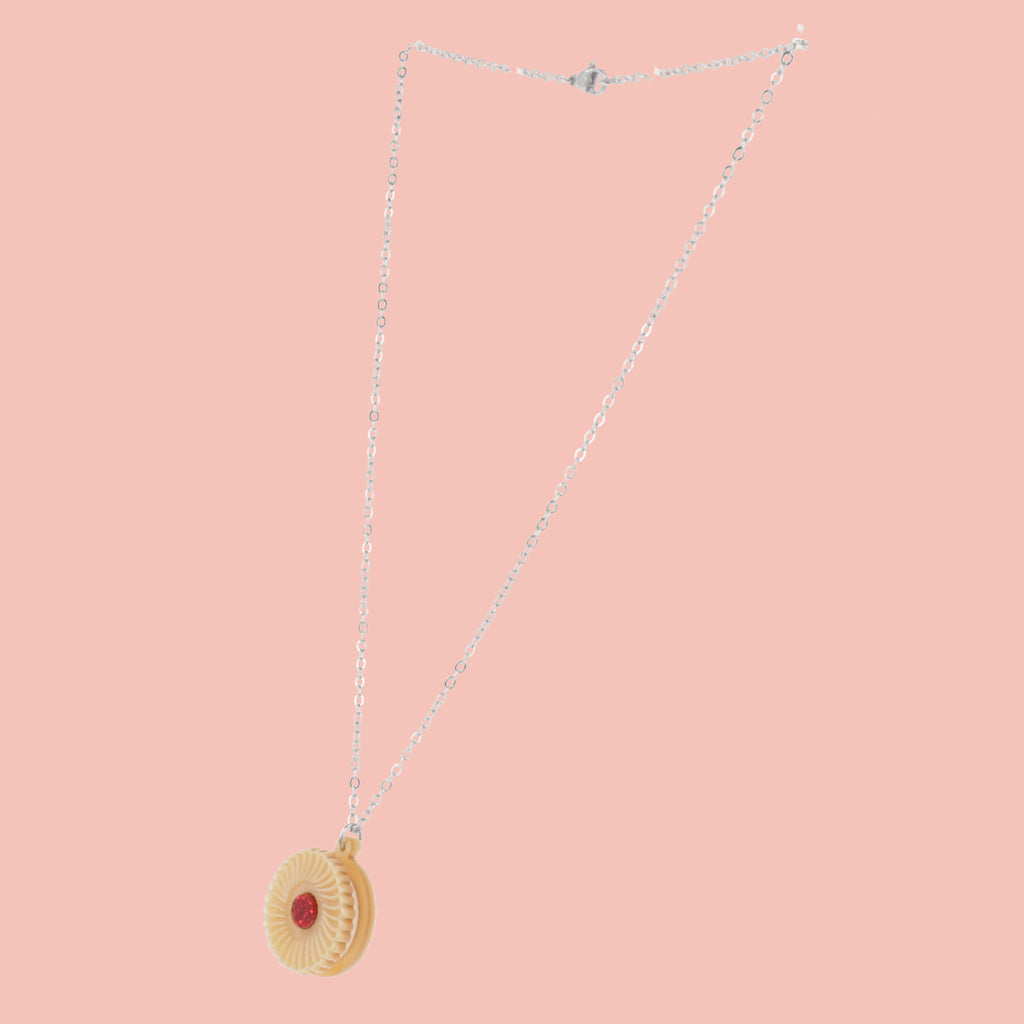 Necklace featuring a pendant of a jam and cream biscuit, on a pink background