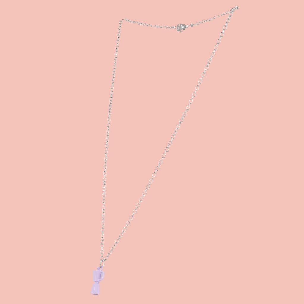 Necklace with a purple coffee pot pendant on a pink background