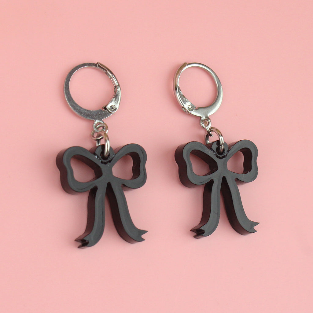Black bow charms on stainless steel huggie hoops