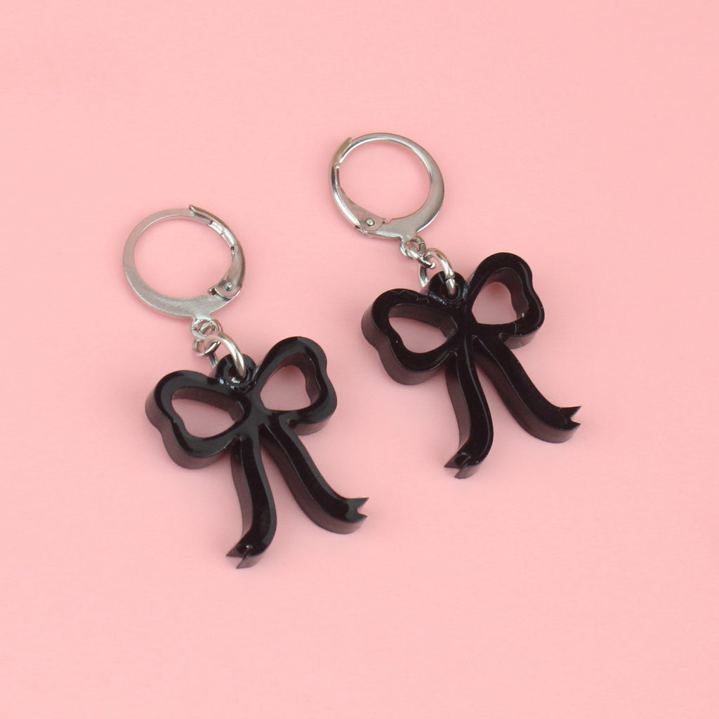 Black bow charms on stainless steel huggie hoops