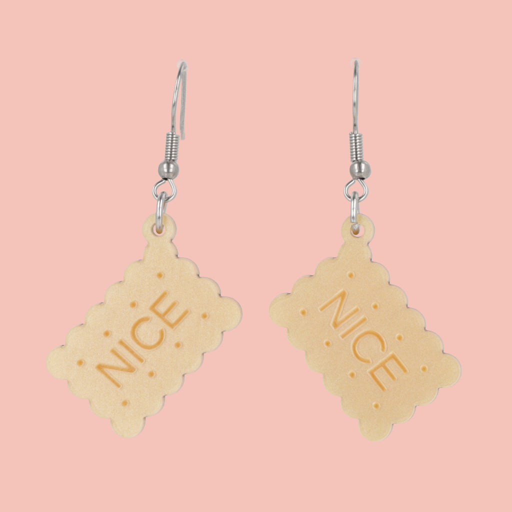 Earrings with nice biscuit charms on a pink background