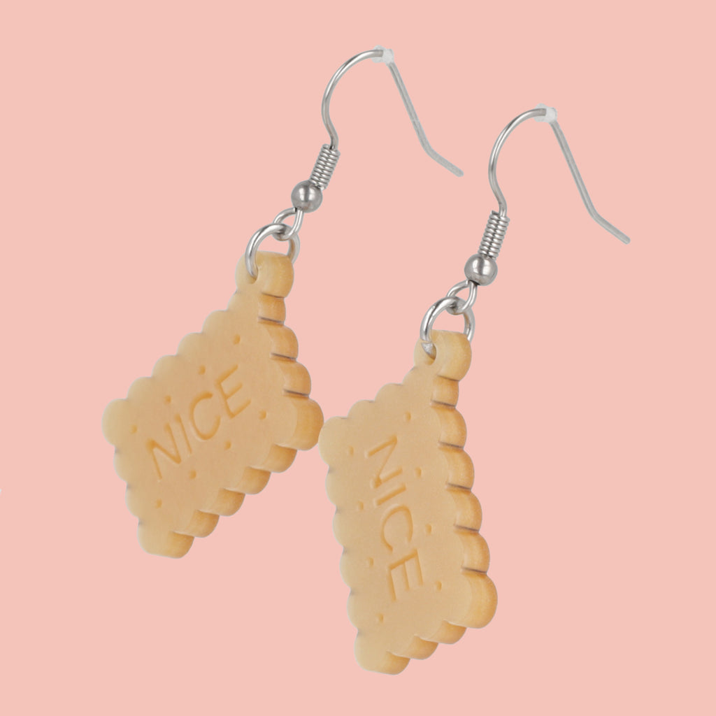 Earrings with nice biscuit charms on a pink background