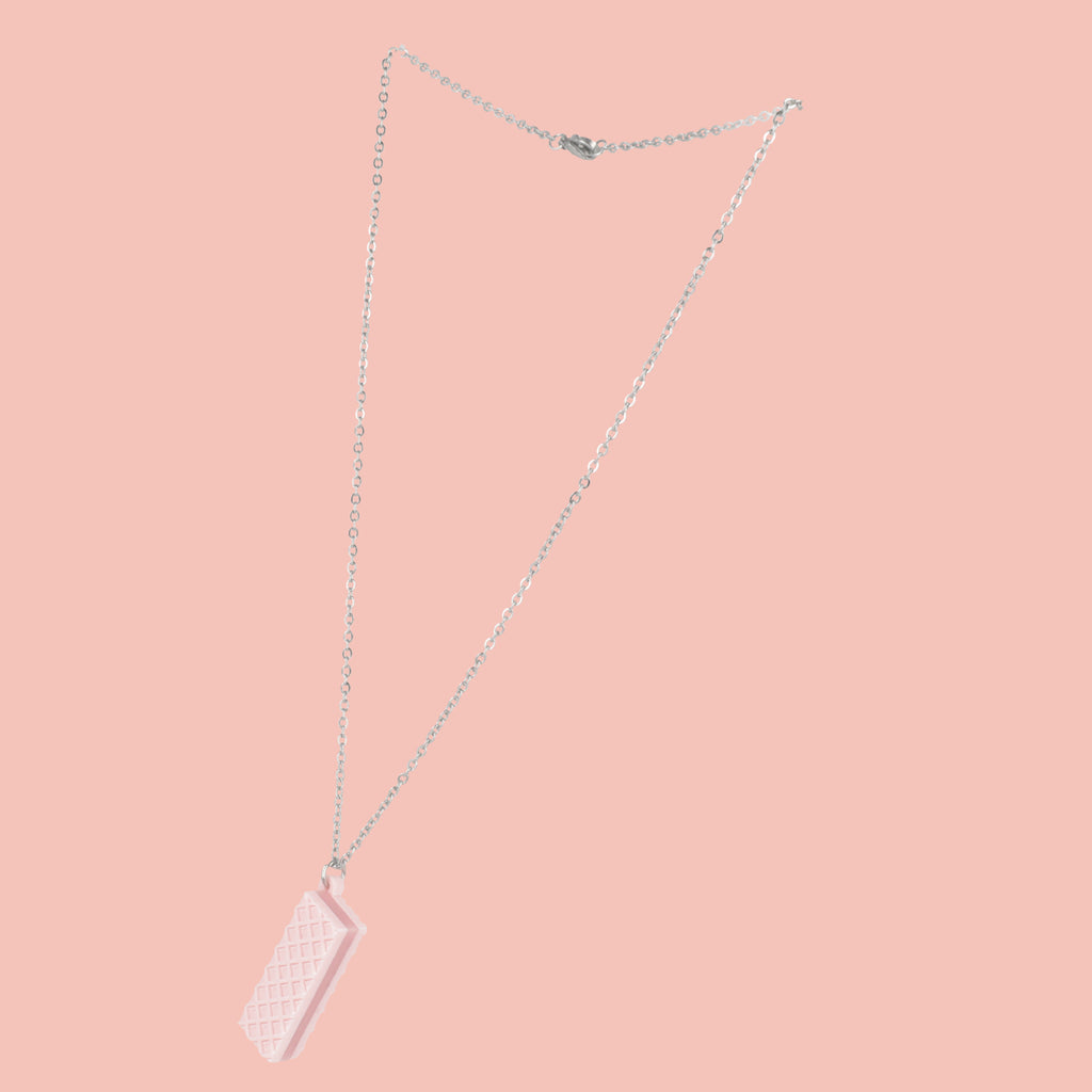 Necklace with a pink wafer pendant on a pink background