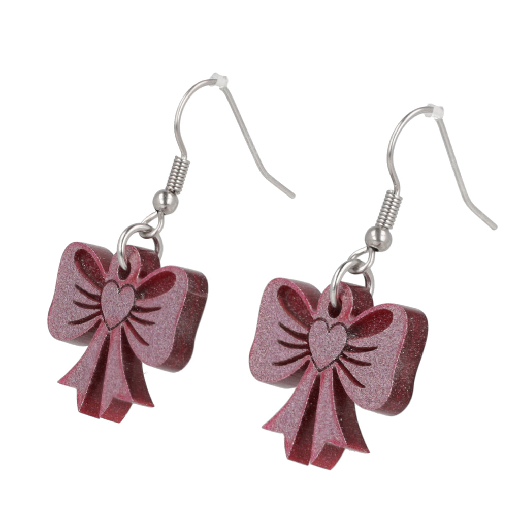 Pink glittery bow earrings on a white background