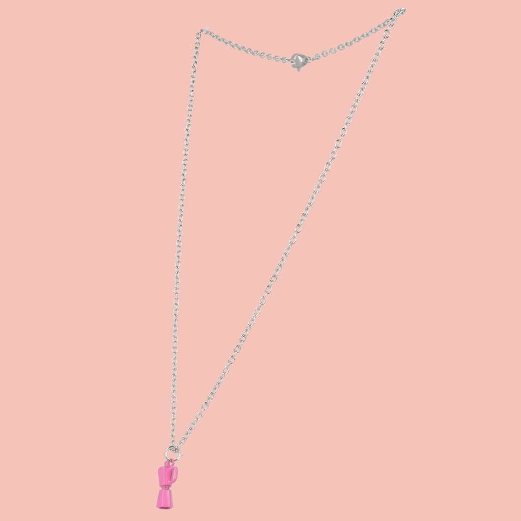 Necklace with a pink coffee pot pendant on a pink background