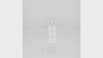THE LETTERS B, O, O SPELLED OUT VERTICALLY WITH A WHITE DRIPPY EFFECT ON STAINLESS STEEL EARWIRES