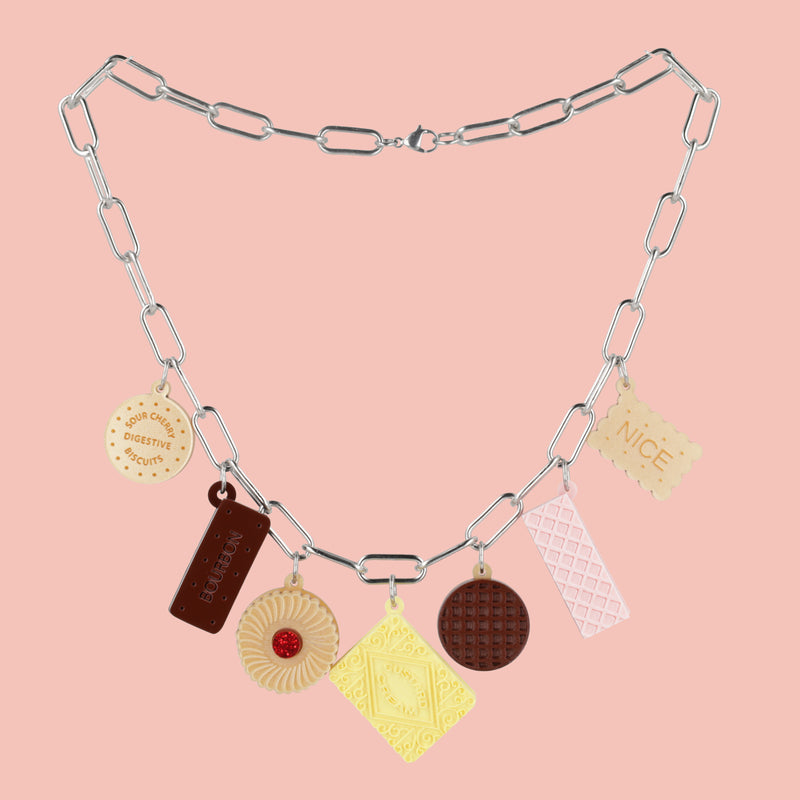 Necklace with various charms on a pink background
