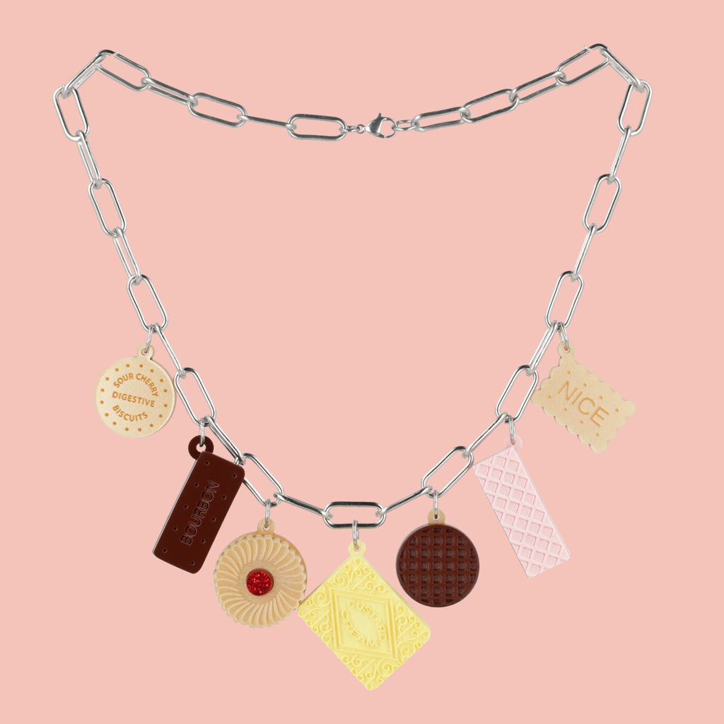 Necklace with various charms on a pink background
