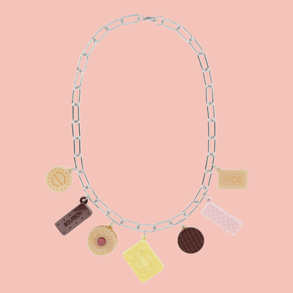 Necklace with various charms on a pink background