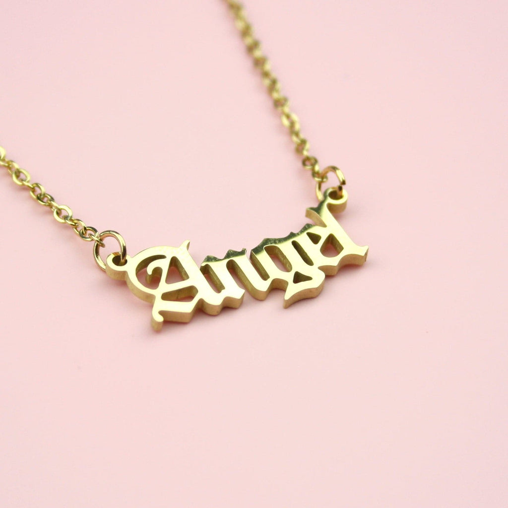 Gold plated stainless steel necklace with the word 'angel' written in a gothic font